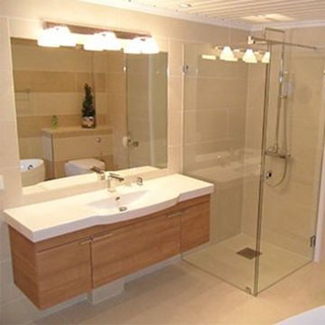 Renovert baderom med dusjhjørne og bred servant med trefront og speilskap